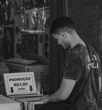 a man standing in front of a store holding a box